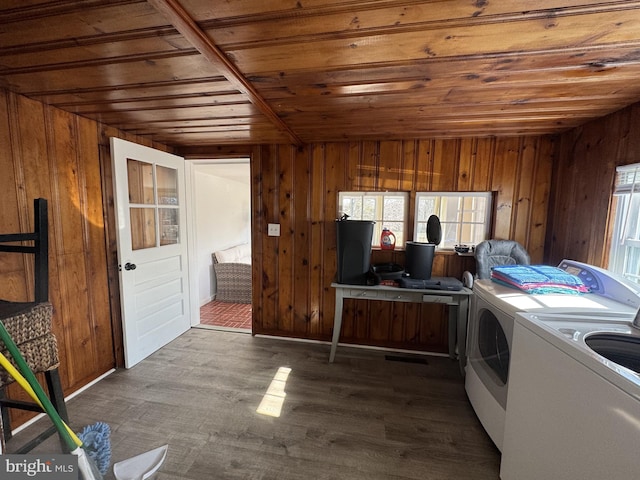 laundry room featuring dark wood-style floors, wooden ceiling, wood walls, separate washer and dryer, and laundry area