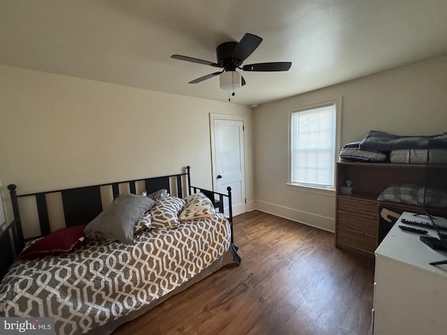 bedroom featuring dark wood finished floors, a ceiling fan, and baseboards