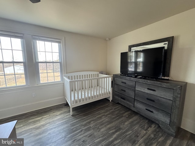 bedroom with dark wood-style floors and baseboards