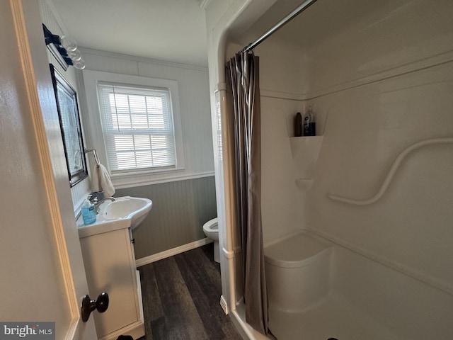 bathroom with wainscoting, toilet, wood finished floors, vanity, and a shower stall