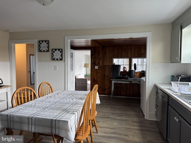 dining room with dark wood-style floors and a wainscoted wall