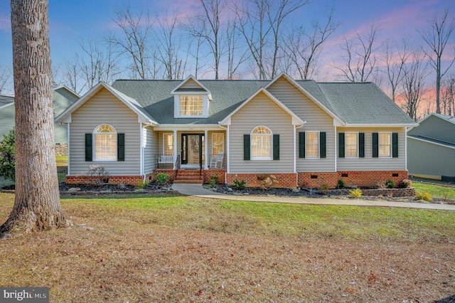 view of front of house with a shingled roof, crawl space, and a yard