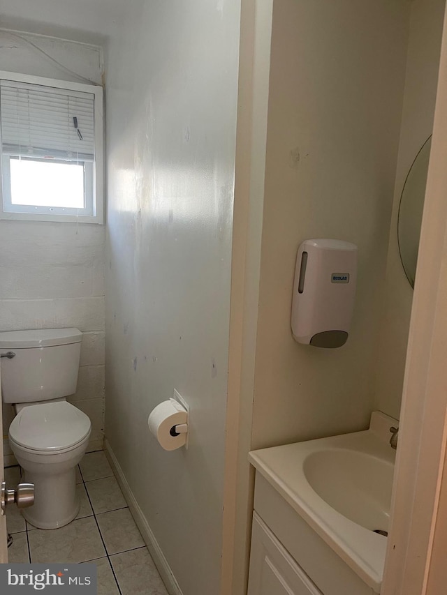 bathroom featuring tile patterned flooring, baseboards, vanity, and toilet