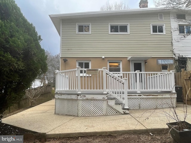 back of property featuring a chimney, stucco siding, a patio area, fence, and a deck