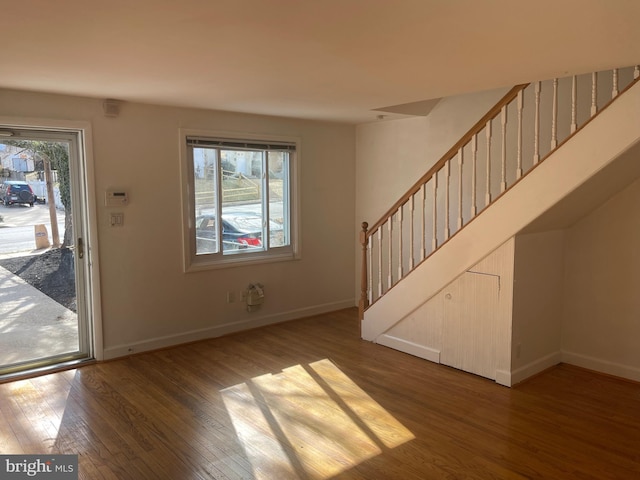 interior space featuring baseboards, stairway, and wood finished floors