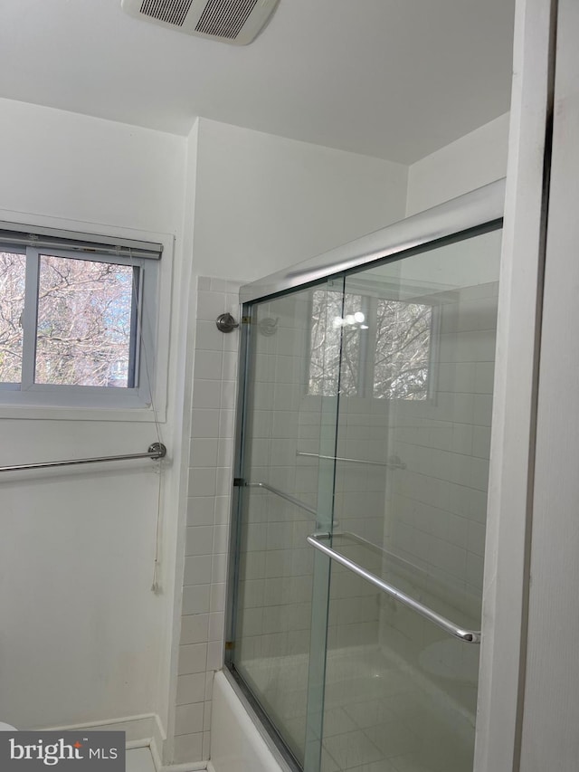 bathroom with visible vents and combined bath / shower with glass door