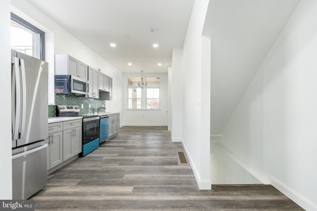 kitchen with visible vents, appliances with stainless steel finishes, backsplash, light countertops, and a sink