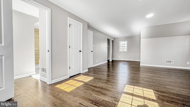 unfurnished room with visible vents, baseboards, wood finished floors, and recessed lighting