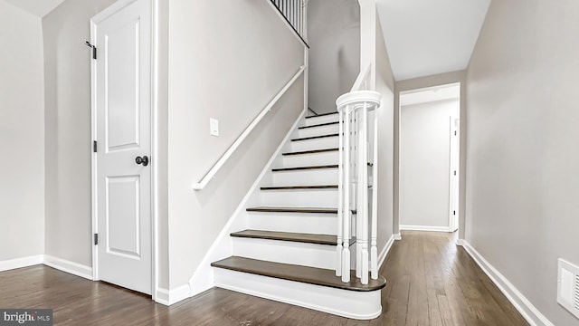 stairway with baseboards and wood finished floors