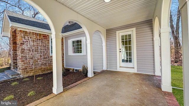 view of exterior entry with a shingled roof