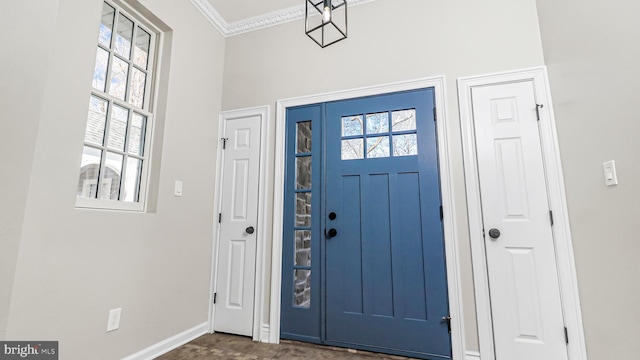 foyer with ornamental molding and baseboards