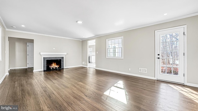 unfurnished living room featuring crown molding, visible vents, and baseboards