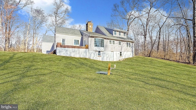 view of side of property featuring a lawn and a chimney