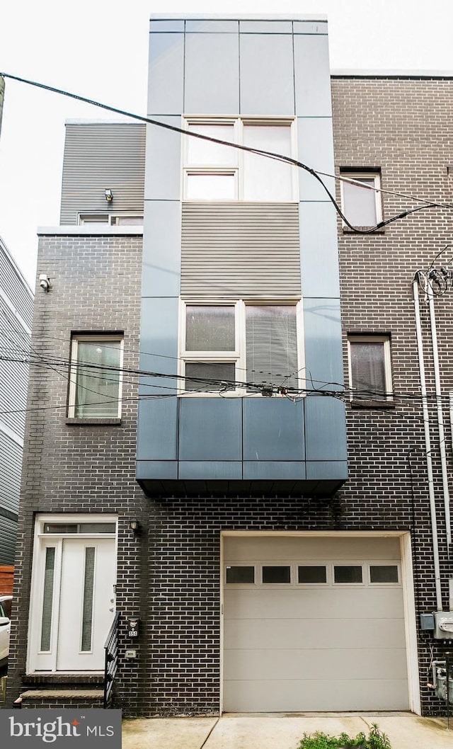 exterior space featuring concrete driveway and an attached garage