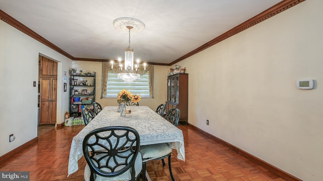 dining space with ornamental molding, an inviting chandelier, and baseboards