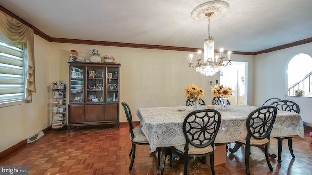 dining area featuring crown molding, an inviting chandelier, visible vents, and baseboards