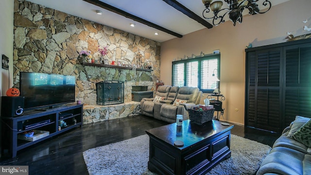 living room featuring beamed ceiling, a chandelier, dark wood-style flooring, and a stone fireplace