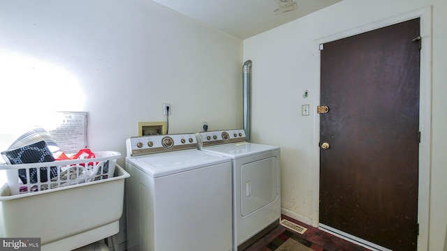 clothes washing area with laundry area, washer and clothes dryer, and baseboards