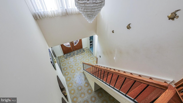 stairway featuring a chandelier