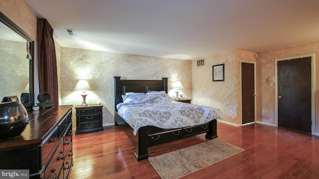 bedroom with dark wood-style flooring, visible vents, and baseboards