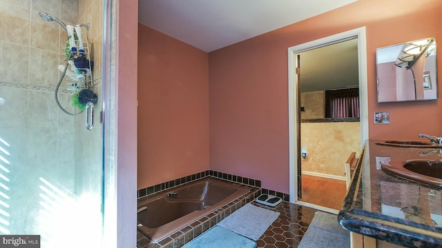 full bath with a tile shower, double vanity, a sink, and tile patterned floors