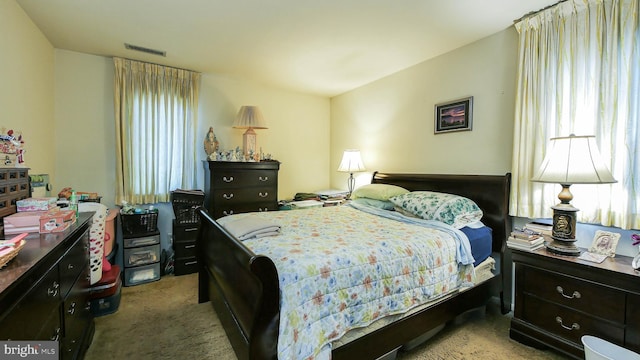 bedroom featuring visible vents and light colored carpet