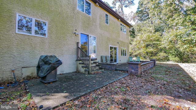 back of property with a patio area and stucco siding