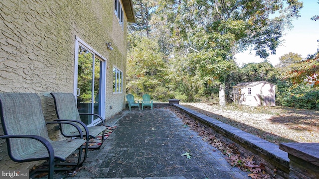 view of yard featuring a storage unit, an outdoor structure, and a patio