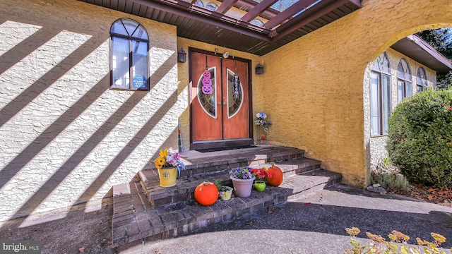 entrance to property featuring stucco siding