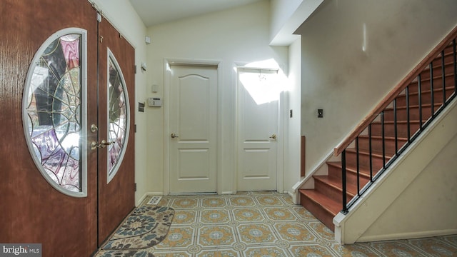 foyer entrance with vaulted ceiling, french doors, stairway, and a wealth of natural light