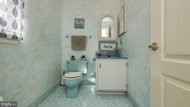 half bathroom with toilet, wallpapered walls, and baseboards