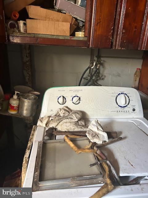 room details featuring washer / dryer and concrete block wall