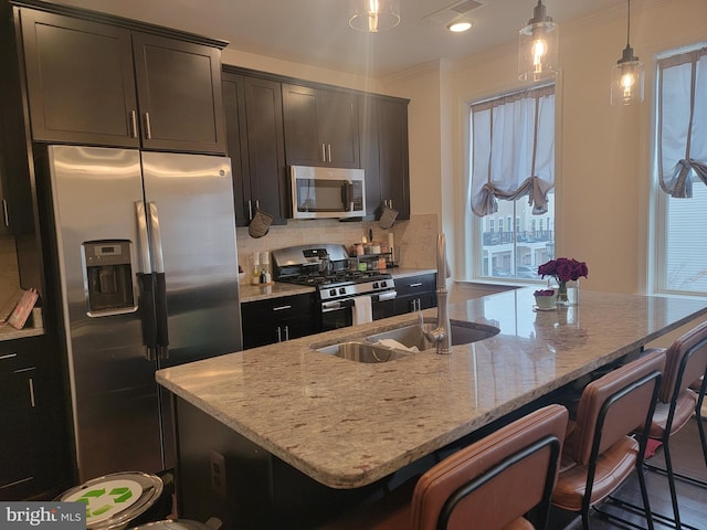 kitchen featuring a center island with sink, a breakfast bar area, and stainless steel appliances