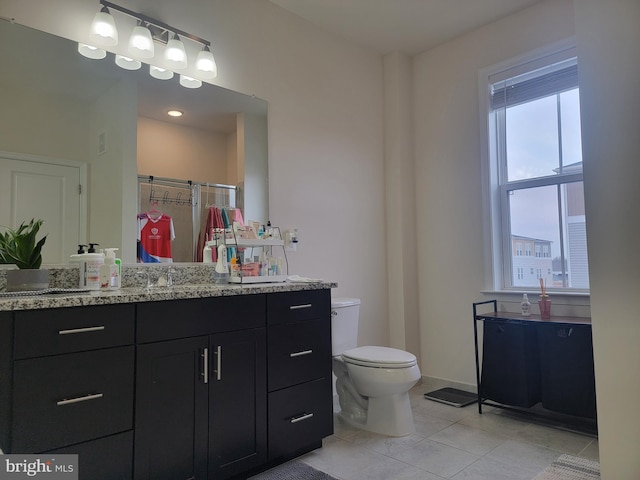 full bath with baseboards, toilet, tile patterned floors, vanity, and a shower stall