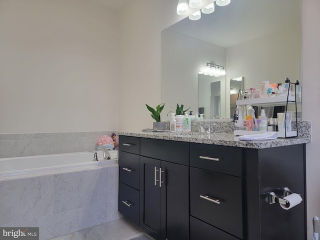 full bathroom featuring a garden tub, vanity, and tile patterned floors