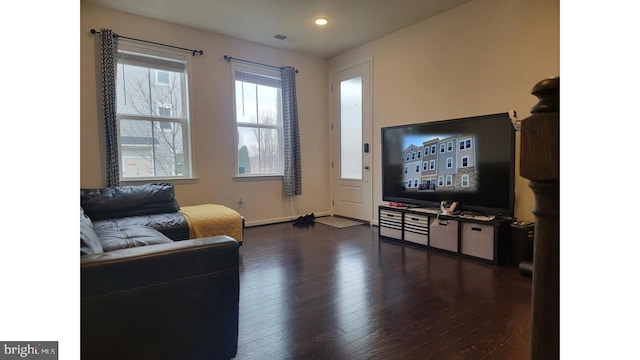 living room featuring baseboards and dark wood-type flooring