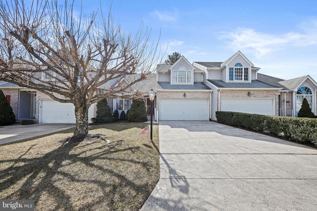 view of front of property with a garage, brick siding, driveway, and roof with shingles