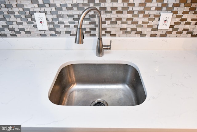 interior details featuring light stone countertops and a sink