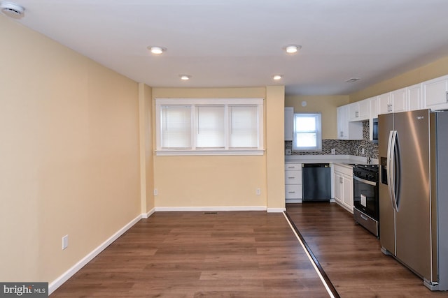 kitchen with tasteful backsplash, dark wood-type flooring, stainless steel appliances, light countertops, and white cabinetry