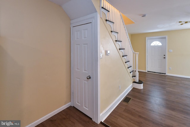 entryway with stairway, baseboards, visible vents, and dark wood-type flooring