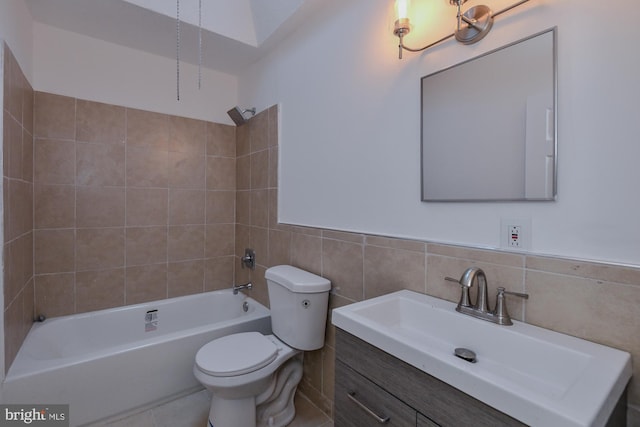 bathroom featuring toilet, a wainscoted wall, vanity, tile walls, and  shower combination