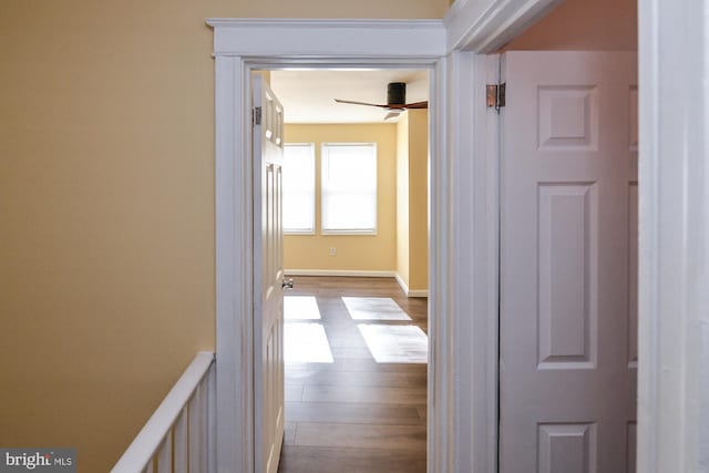 corridor featuring light wood-style flooring and baseboards