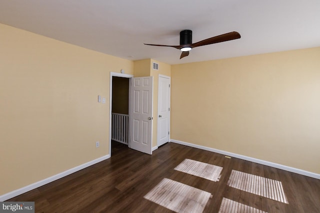 unfurnished bedroom featuring baseboards, visible vents, ceiling fan, and dark wood-type flooring