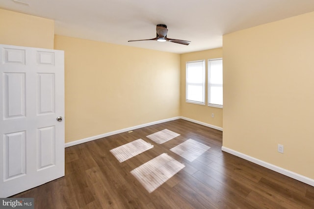 unfurnished room featuring a ceiling fan, dark wood finished floors, and baseboards