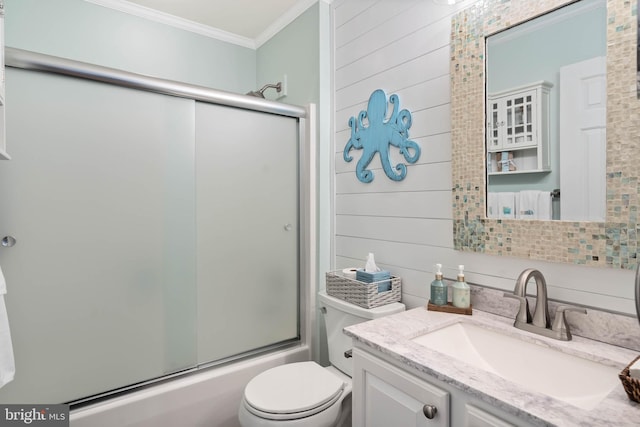 bathroom featuring shower / bath combination with glass door, crown molding, vanity, and toilet