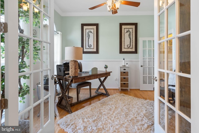 office area with a wainscoted wall, french doors, wood finished floors, and crown molding