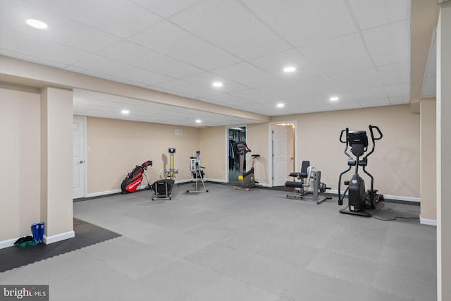 workout room with baseboards, a drop ceiling, and recessed lighting