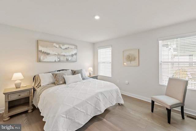 bedroom featuring light wood-style floors and baseboards