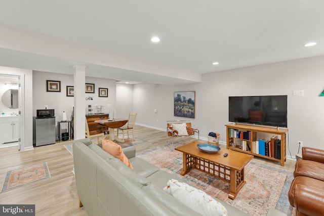 living room featuring baseboards, light wood finished floors, and recessed lighting