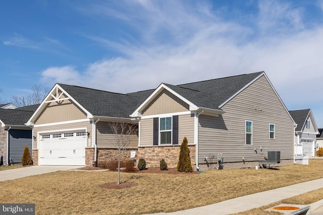 view of front of house featuring a garage, a front yard, concrete driveway, and roof with shingles